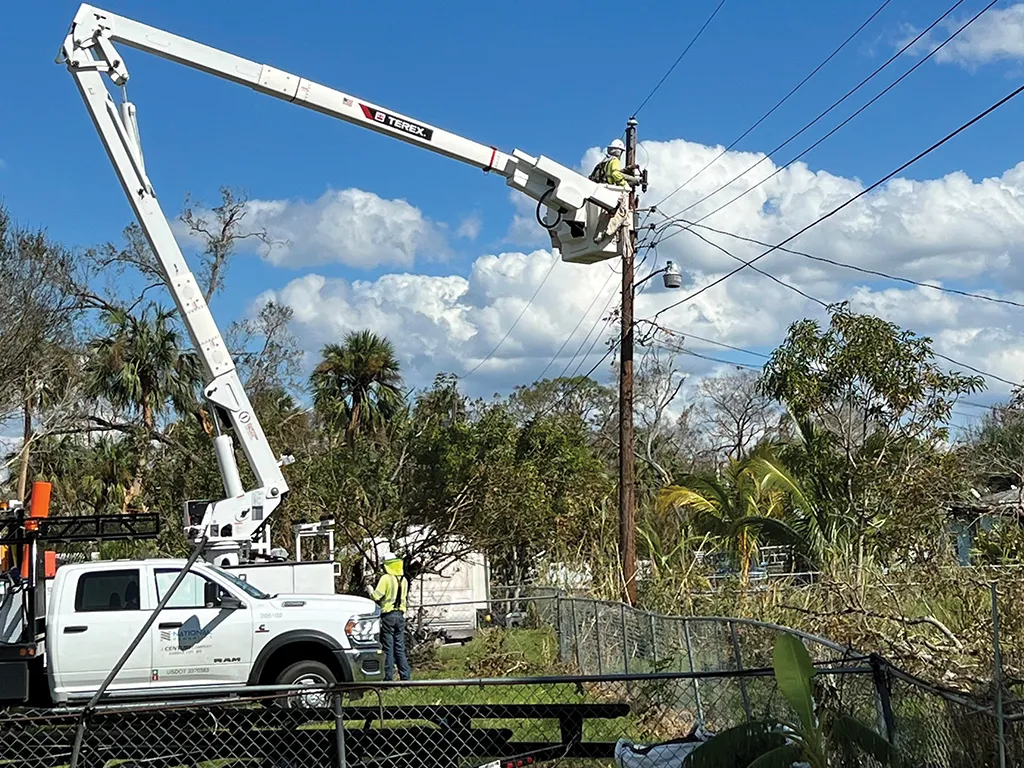 National Powerline worker repairs power line from a lift after a storm.